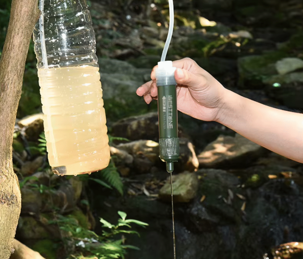 Filtro de agua portátil Nomad Filter adaptado a una botella de plástico tipo Coca-Cola
